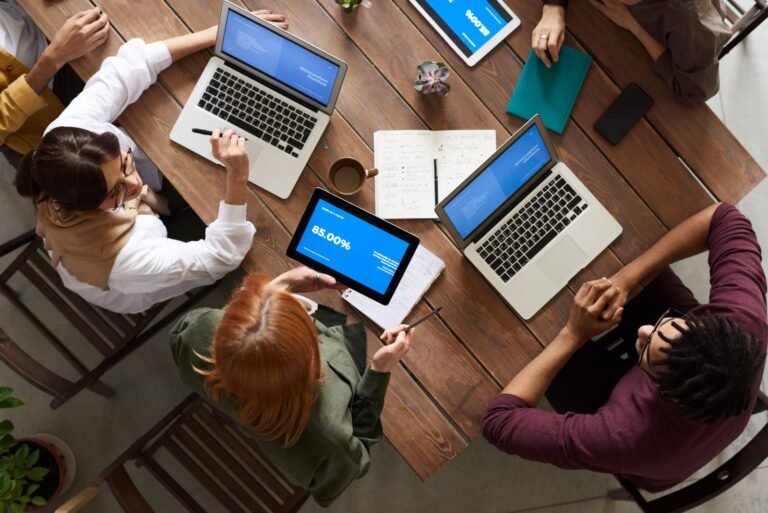 Team planning business website must-haves around a laptop